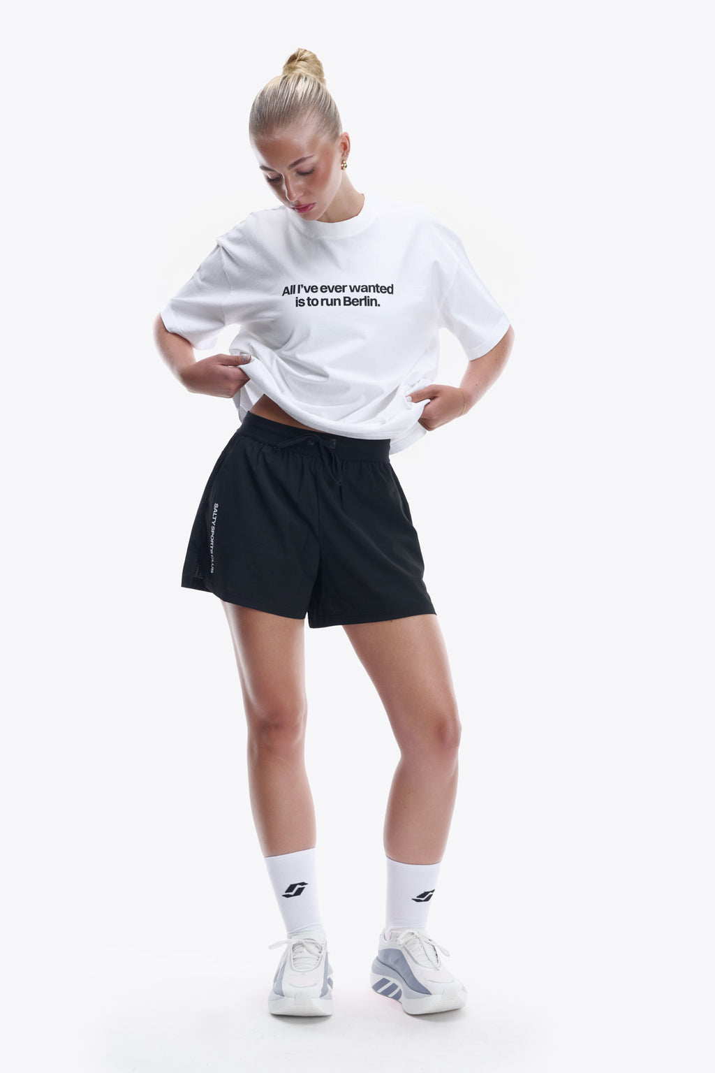 Model in the BERLIN TEE, white tee printed with "All I've ever wanted is to run Berlin."
