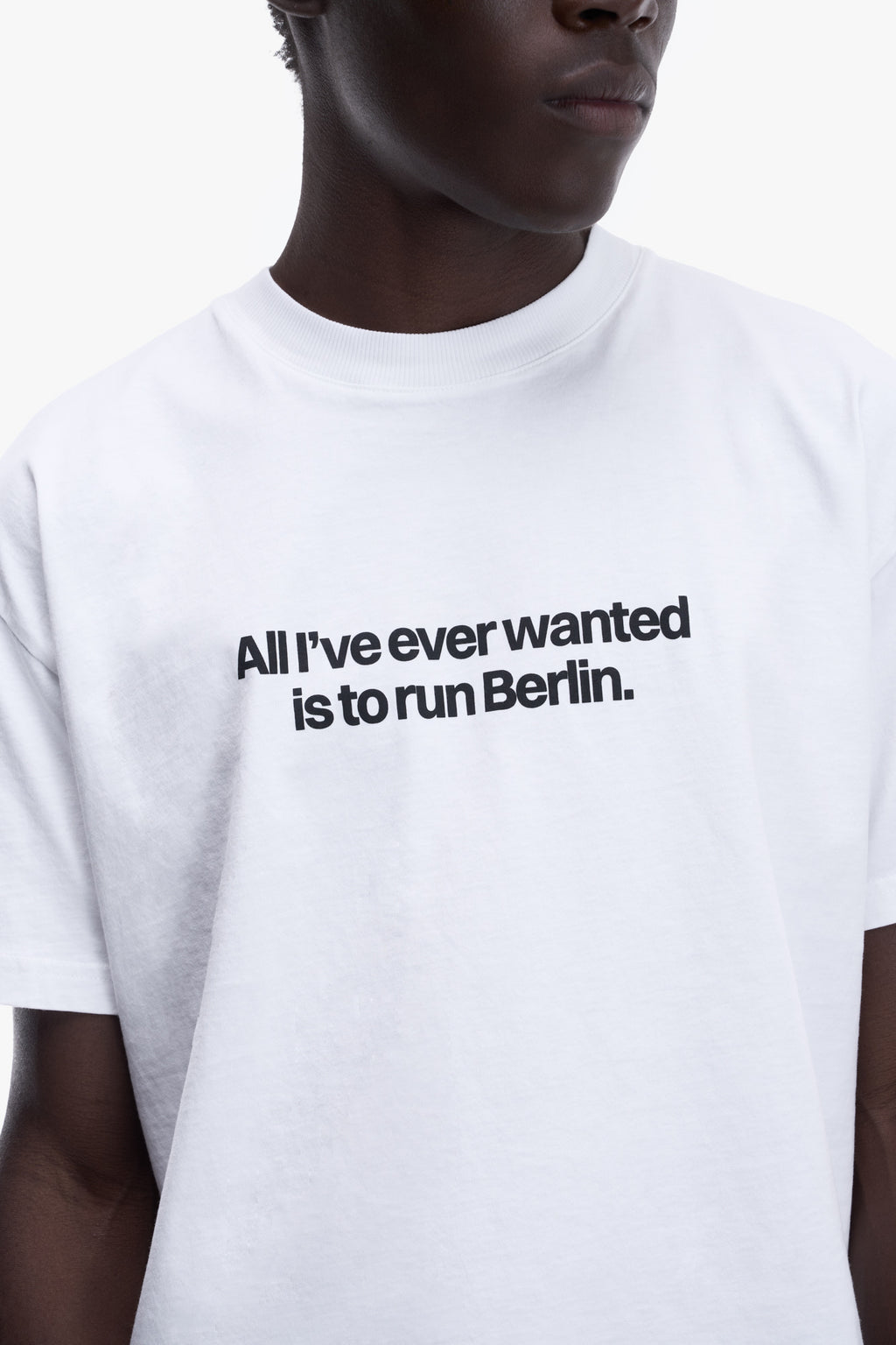 Close-up of the BERLIN TEE print "All I've ever wanted is to run Berlin." in black on white cotton
